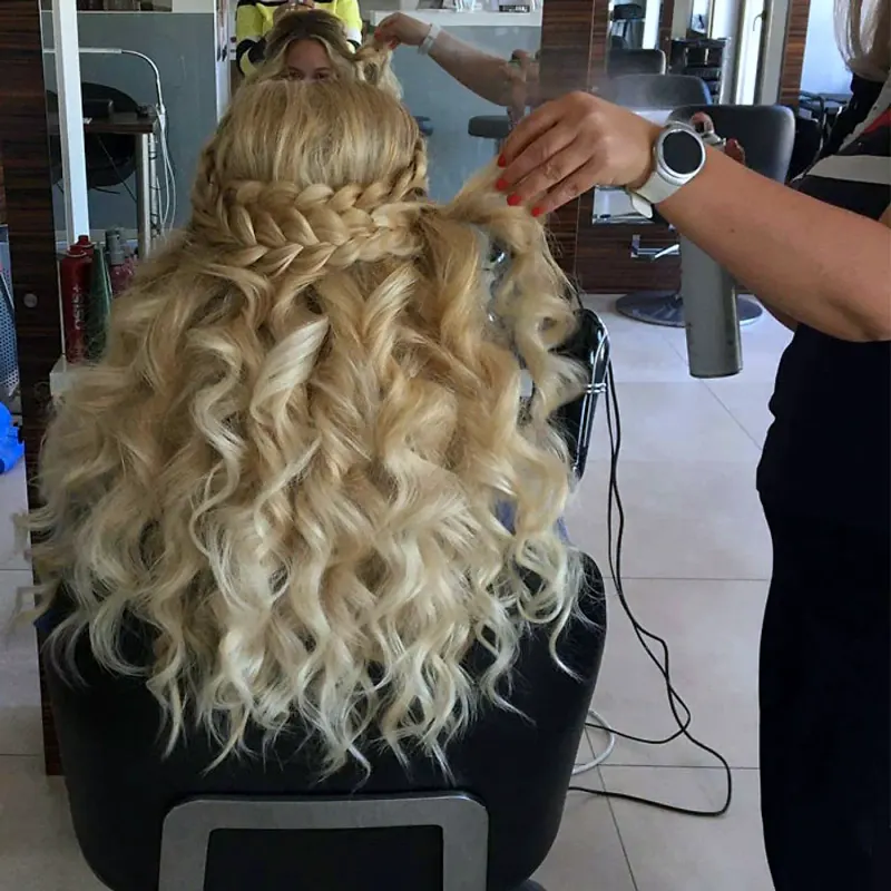 Flechtfrisur mit langen Locken beim Styling im Salon